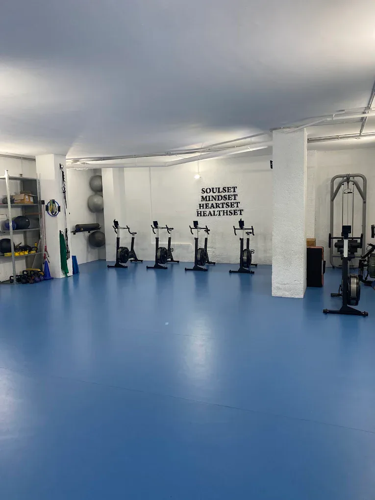 Salle de vélos et de machines cardio avec l'inscription Soulset Mindset Heartset Healthset chez Soriano Trainers