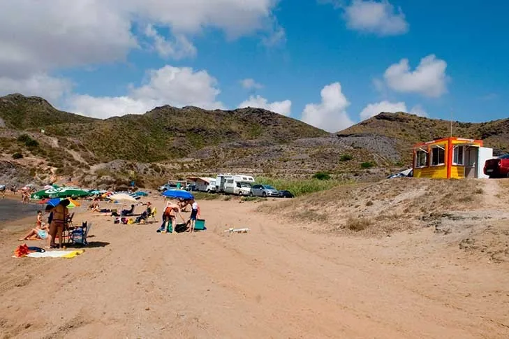 Seasonal beach bar hut on the sand at Cala Reona, with Calblanque's arid hills behind