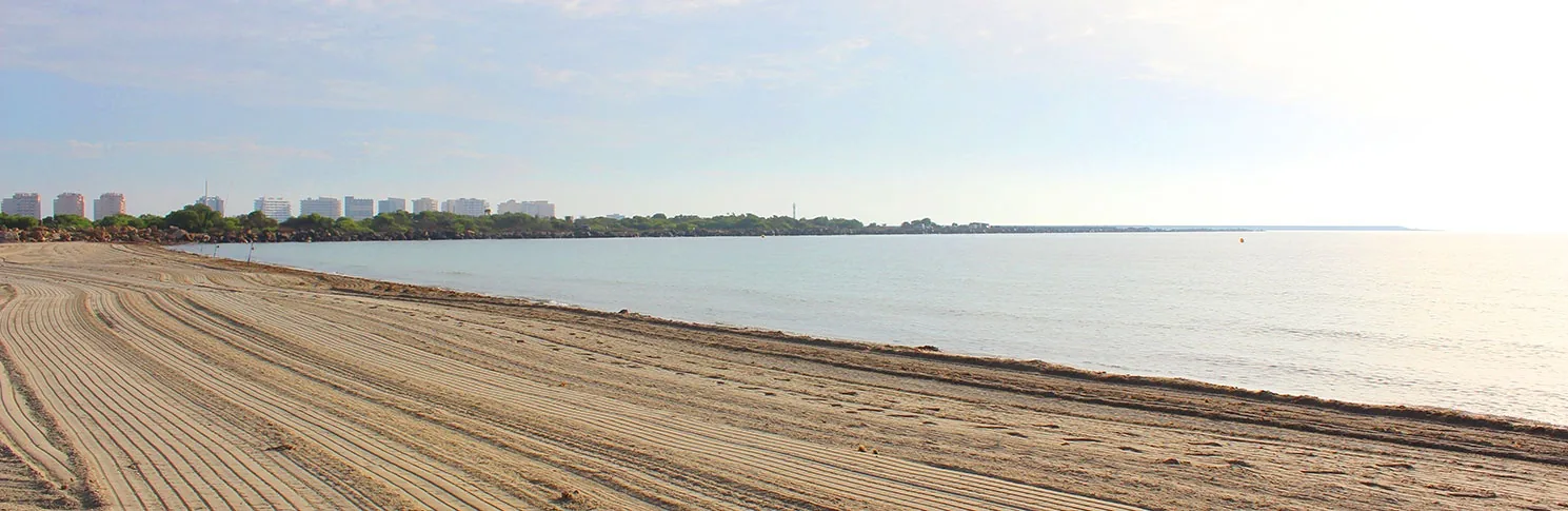 Empty Playa del Estacio with raked sand and the La Manga coastline fading into the distance