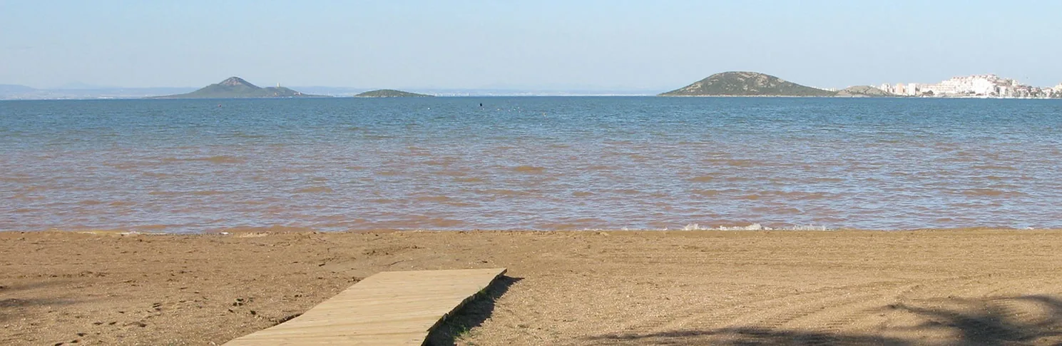 Shallow, calm waters of Mar Menor seen from Playa Honda, with islands and mountains in the background