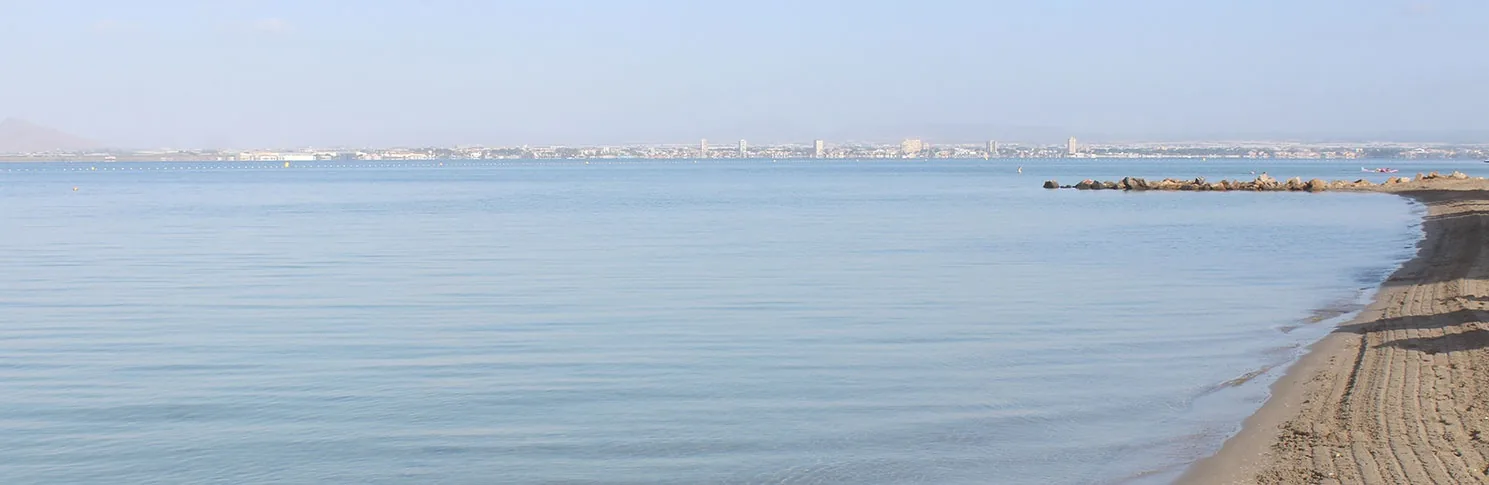 Ruhiges Wasser des Mar Menor in Playa La Veneziola, mit grobsandigem Ufer im Vordergrund
