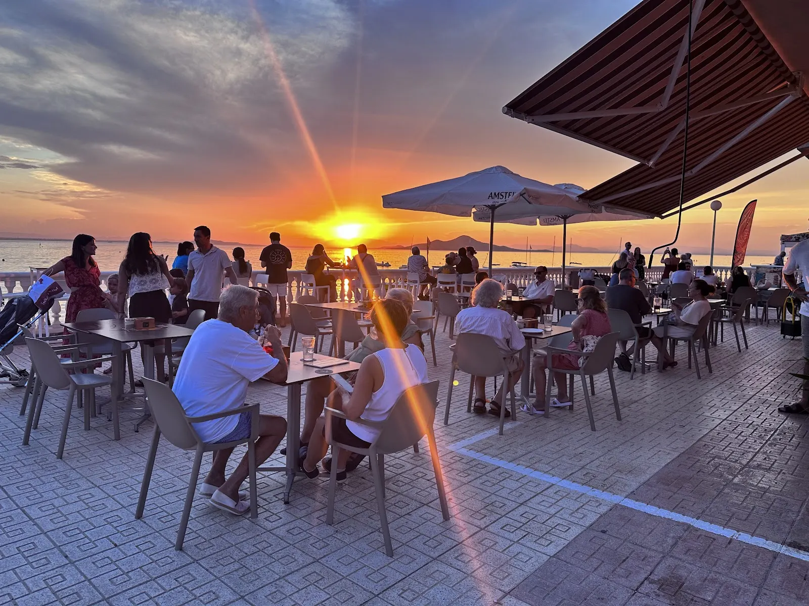 Terrasse d'Amonet au coucher du soleil avec des clients au bord du Mar Menor