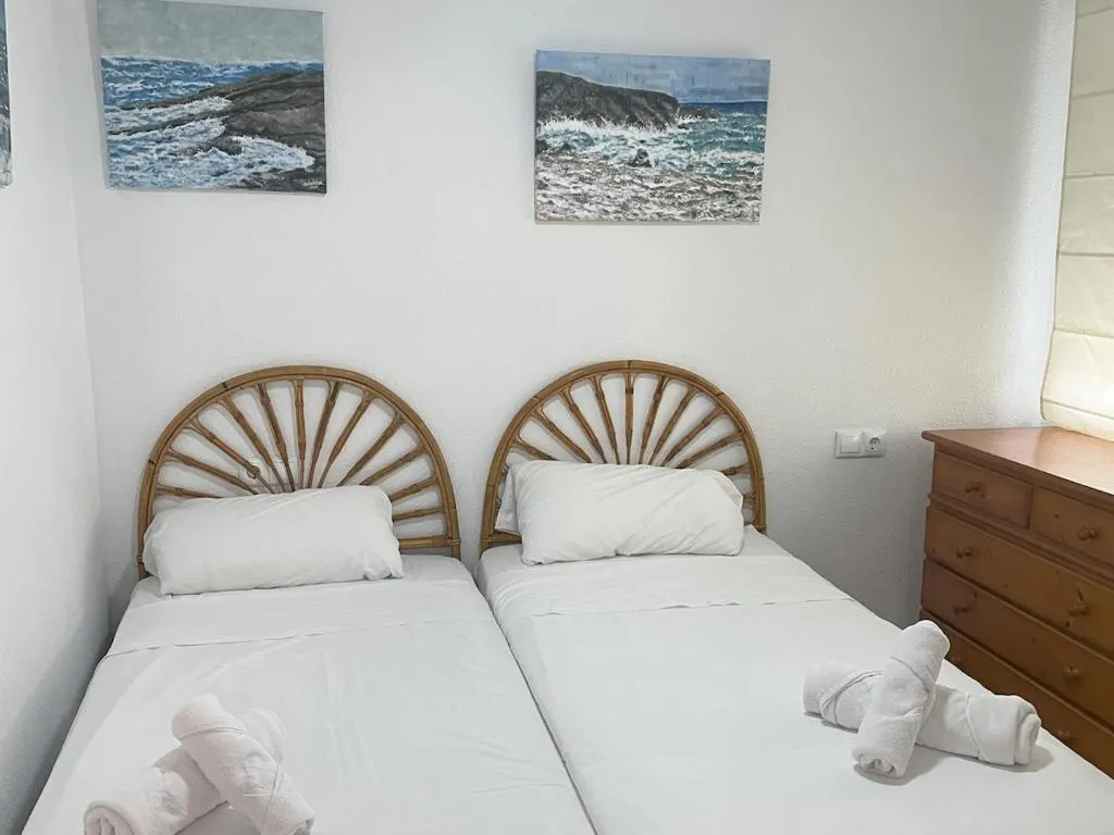 Schlafzimmer des Apartments mit zwei Einzelbetten und Kopfteilen aus Korbgeflecht