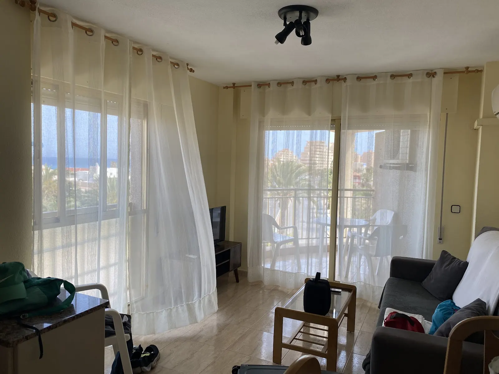 Wohnzimmer mit Vorhängen und Meerblick in einem Apartment im Olympia Center