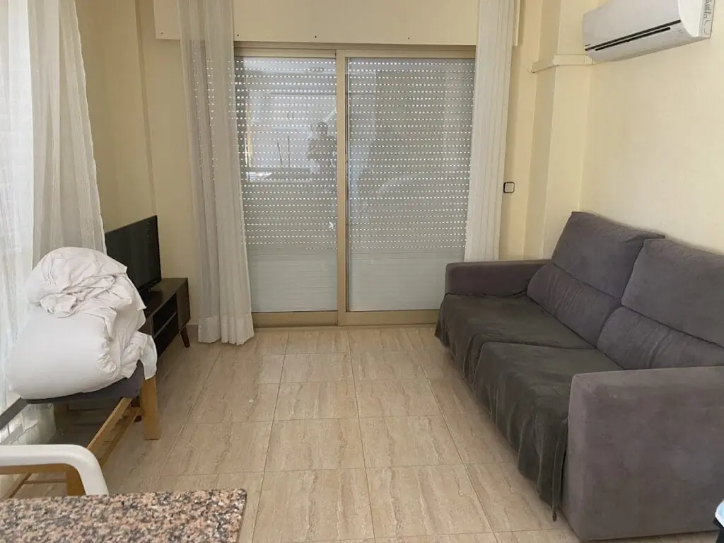 Wohnzimmer mit Sofa und Klimaanlage in einem Apartment im Olympia Center