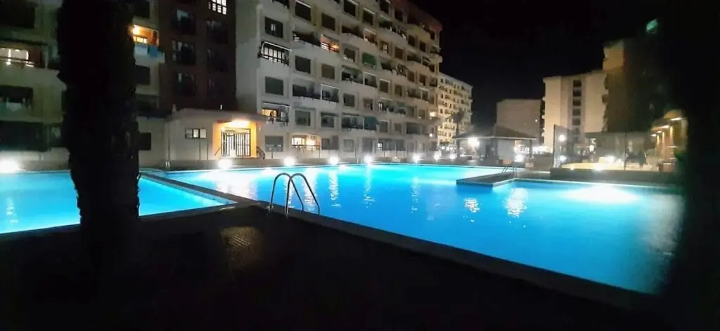 Pool lit up at night in a development managed by Arena Inn