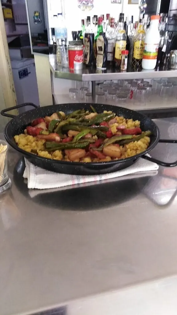 Paella mit Gemüse und Fleisch, serviert an der Theke der Bar Euflo