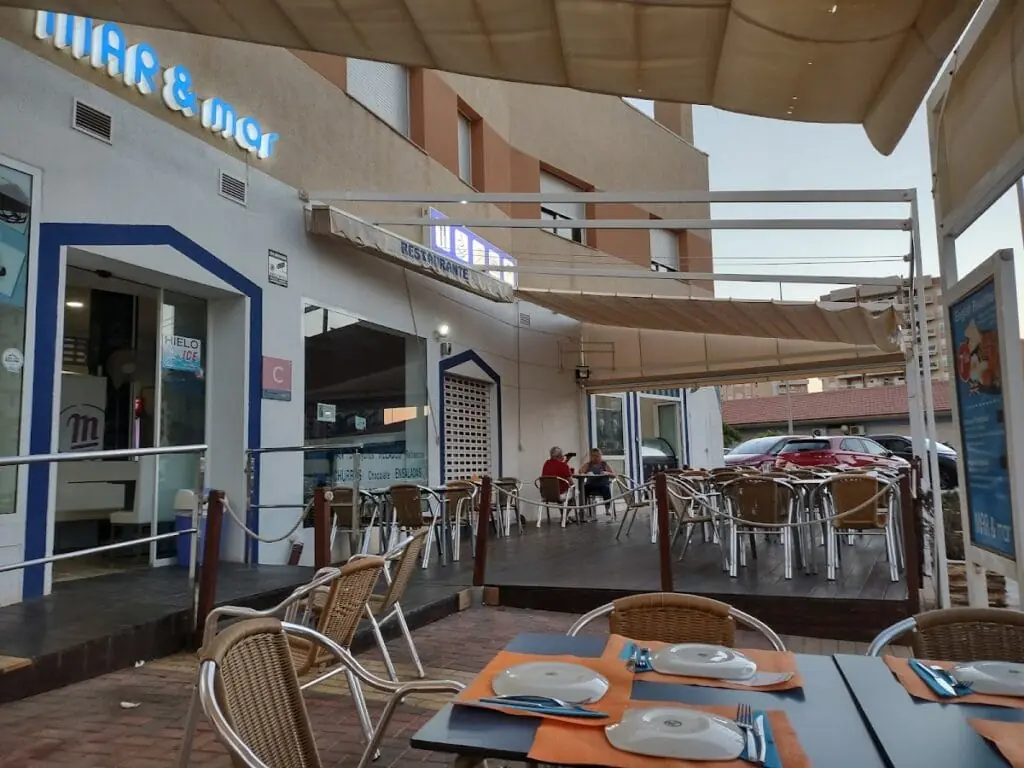 Façade et terrasse du Mar & Mar avec l'enseigne lumineuse du restaurant