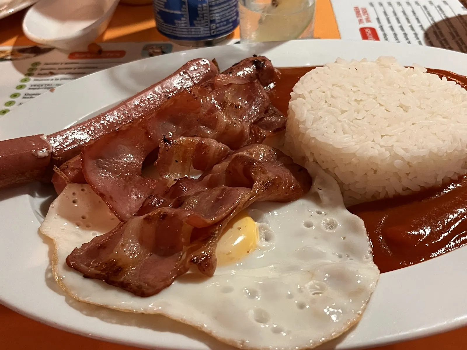 Assiette composée avec œuf au plat, bacon, saucisse et riz au Bar Mortadelo