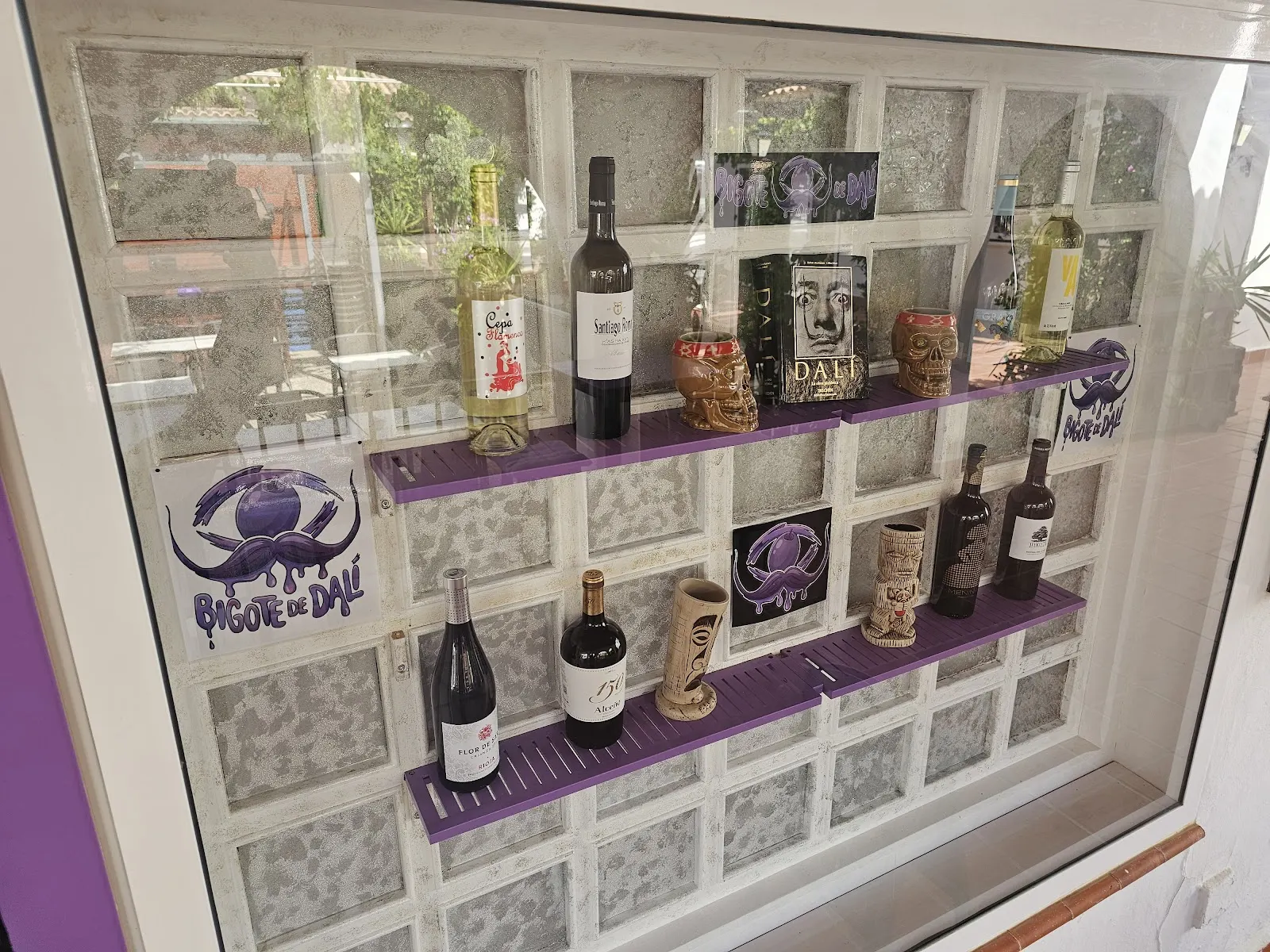 Vitrine avec des bouteilles de vin et décoration sur le thème de Bigote de Dalí