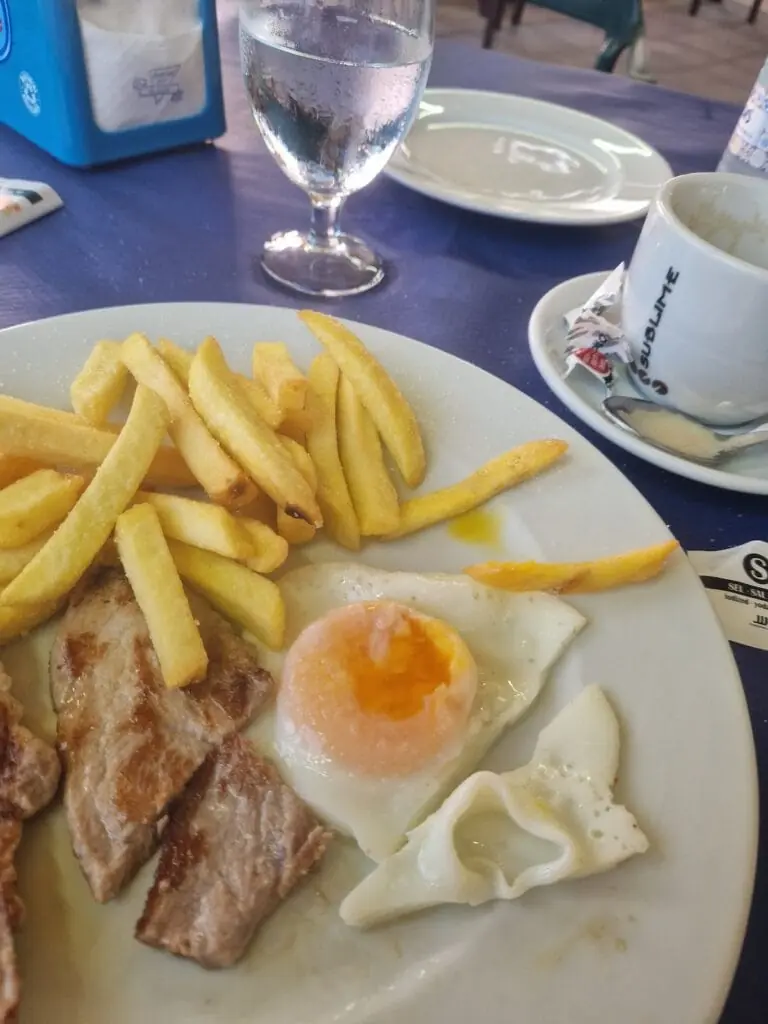 Petit-déjeuner avec œuf au plat, steak et frites servi chez La Victoria