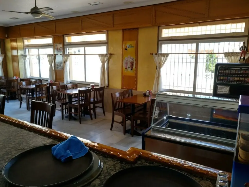 Salle intérieure de la Cafetería Siglo XXI avec tables et vitrine