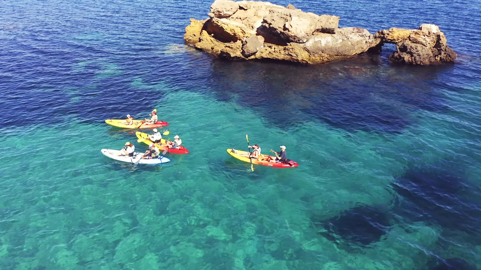 Gruppe von dKayak-Kajaks an einer Felsformation im Meer