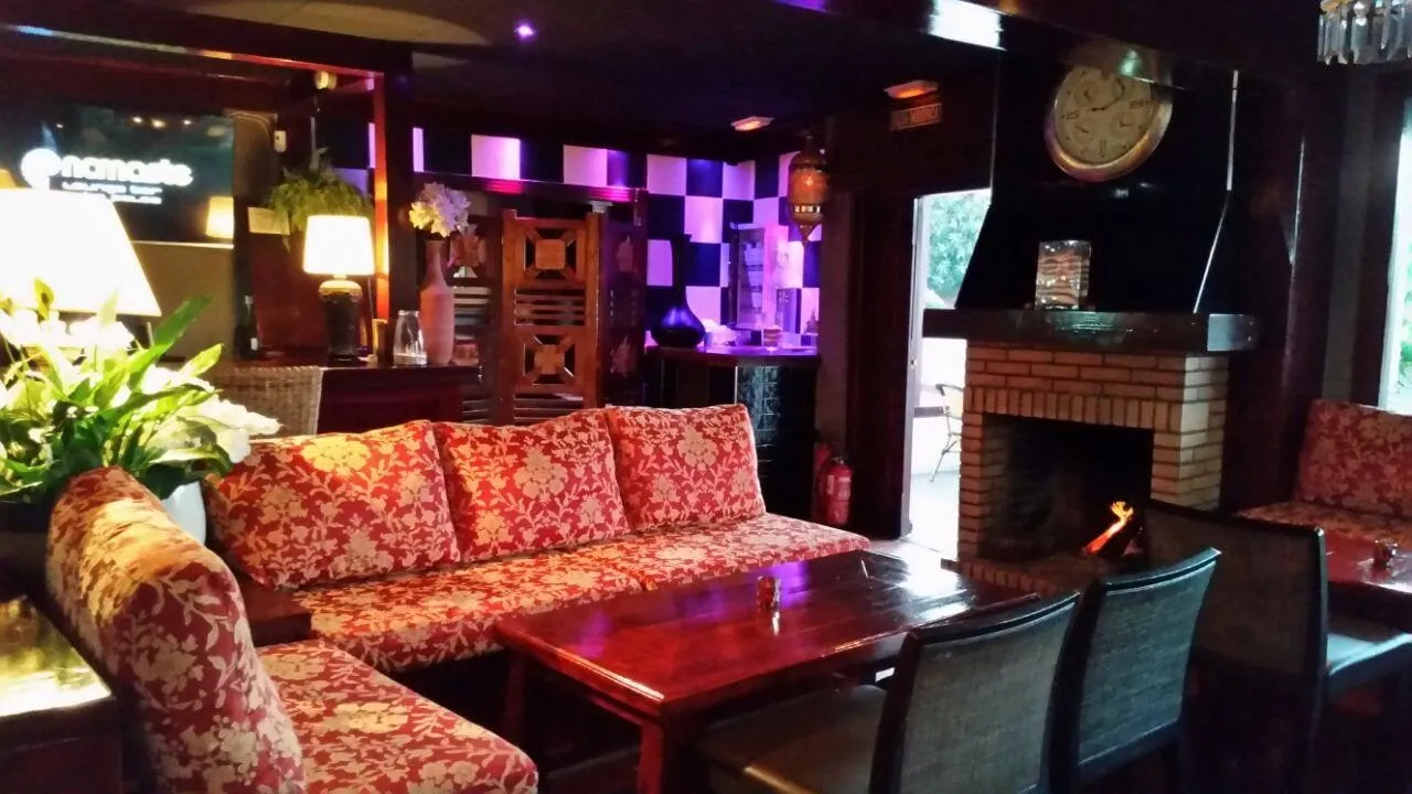 Inside El Capitán, with red sofas, a lit fireplace and a late-night bar atmosphere