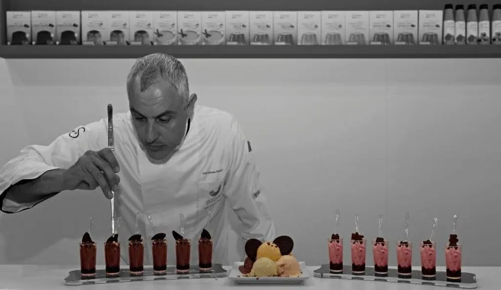 Professionelle Zubereitung von Eisbechern mit Saucen und Schokoladendekoration