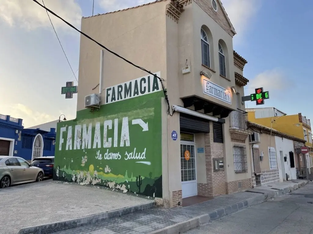 Fassade der Farmacia Cabo De Palos mit grünem Apothekenschild, Calle Sirio