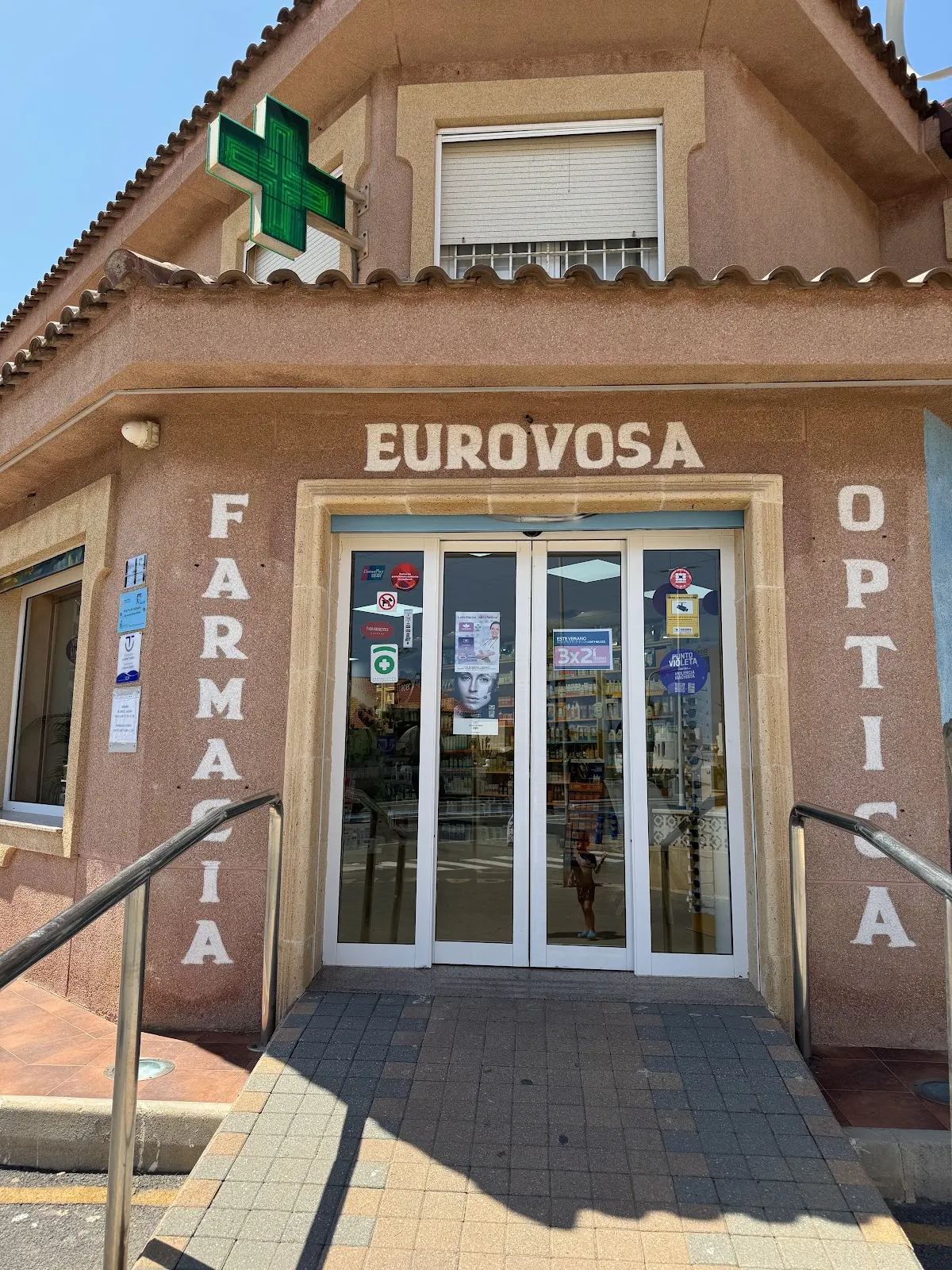 Barrierefreier Eingang von Farmacia Óptica Eurovosa mit dem grünen Kreuz