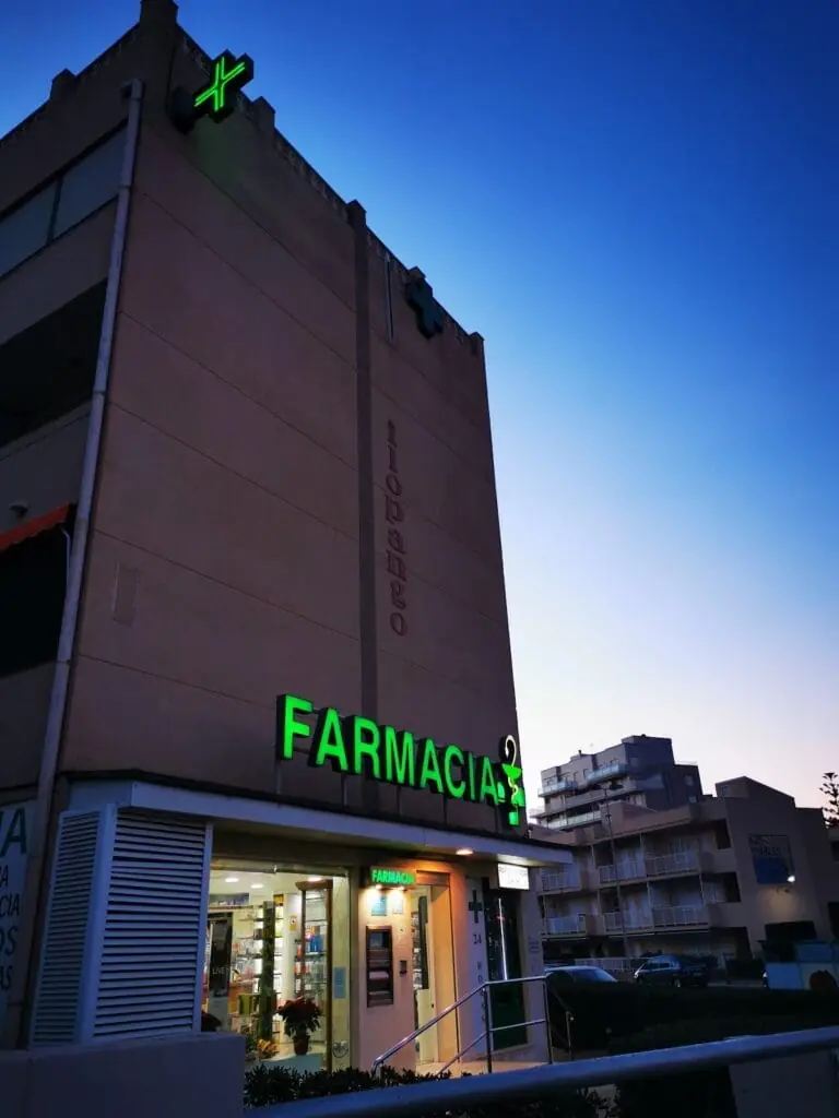 Nachtansicht der Fassade von Farmacia Plaza Bohemia mit beleuchtetem Schild