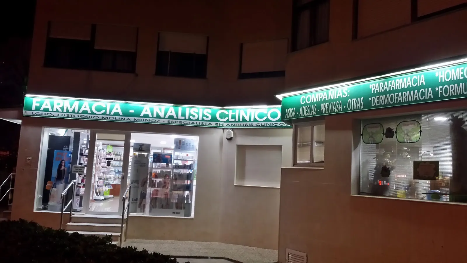 Nachtansicht der Fassade von Farmacia Plaza Bohemia mit dem Schild für klinische Analysen