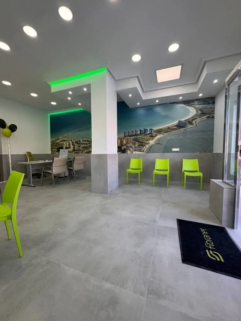 Innenansicht des Ladens Fibranet La Manga mit Stühlen und einem Wandbild der Küste von La Manga