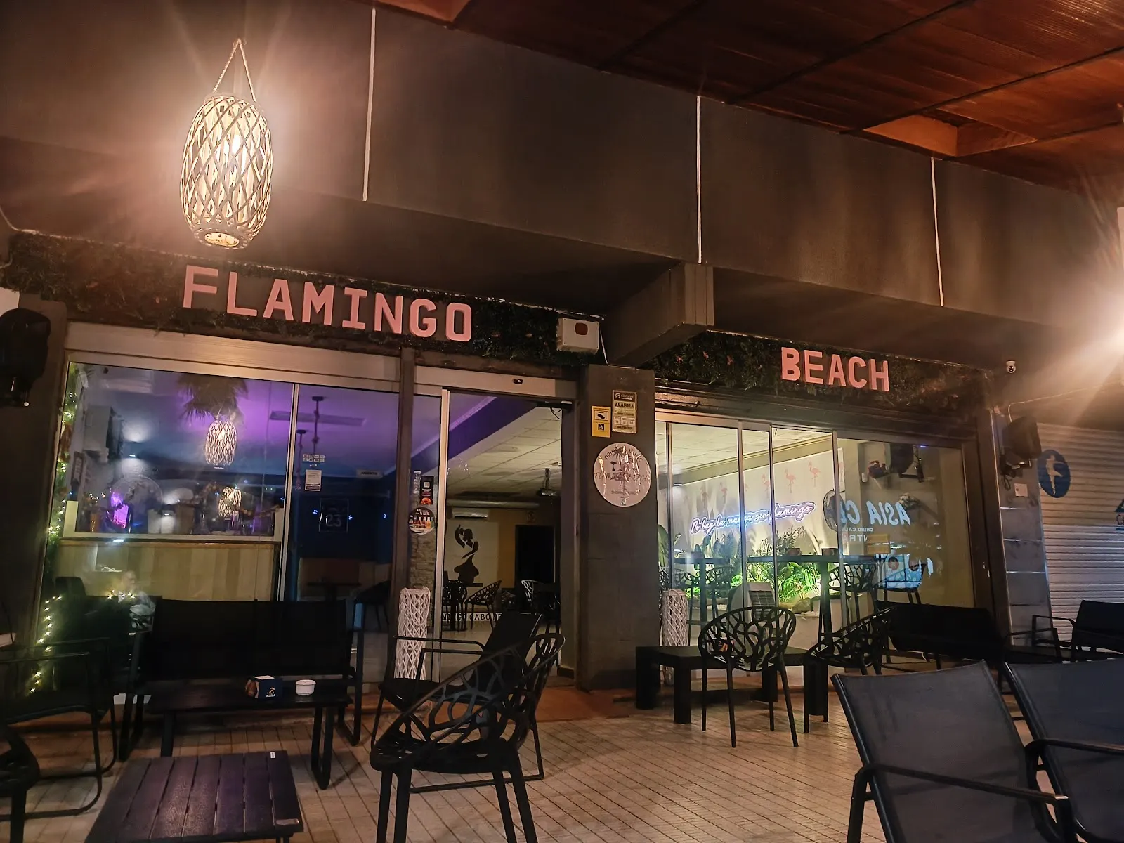 Fassade von Flamingo Beach bei Nacht mit der Außenterrasse