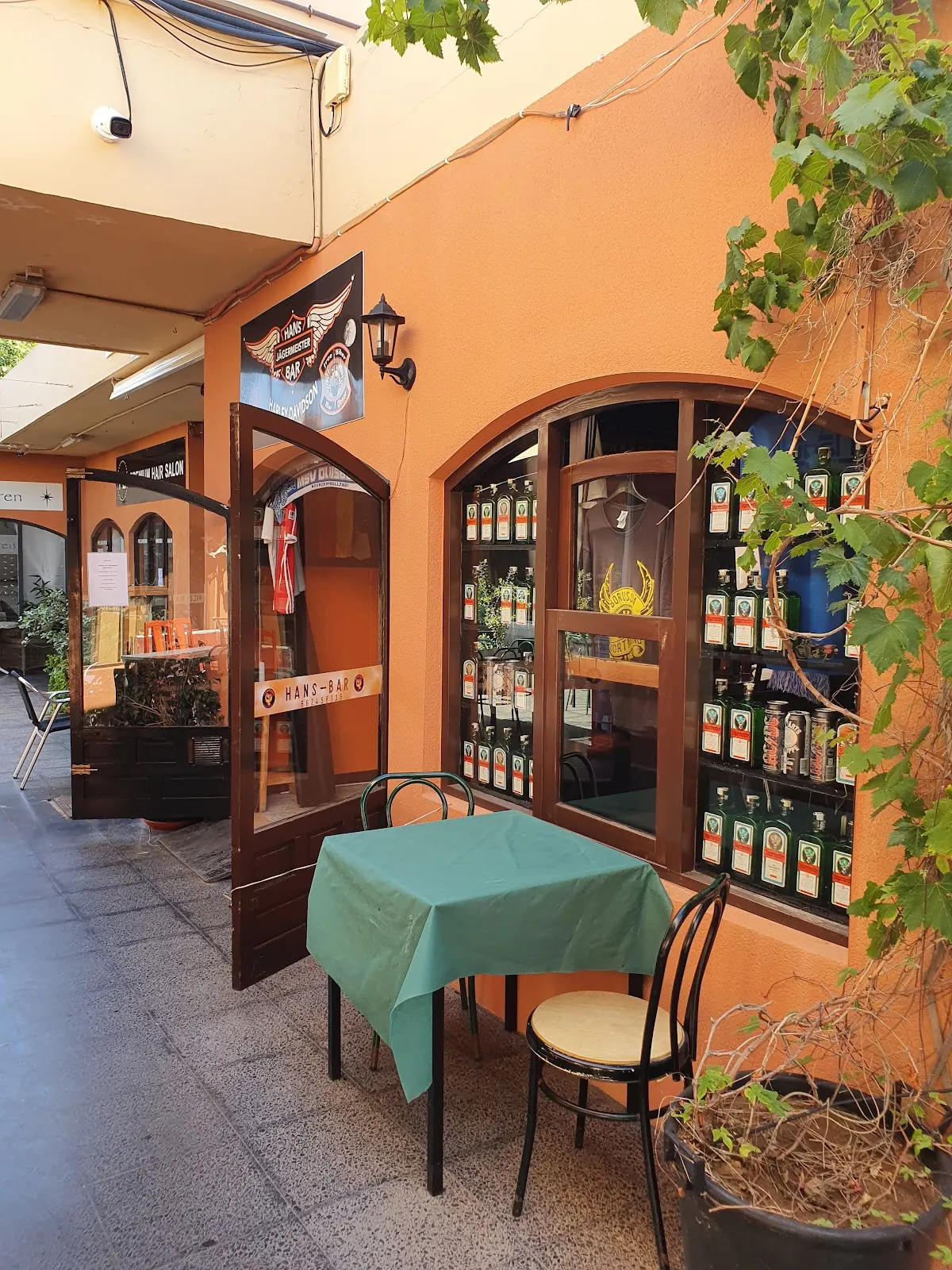 Outdoor terrace at Hans Bar with tables and the entrance to the venue