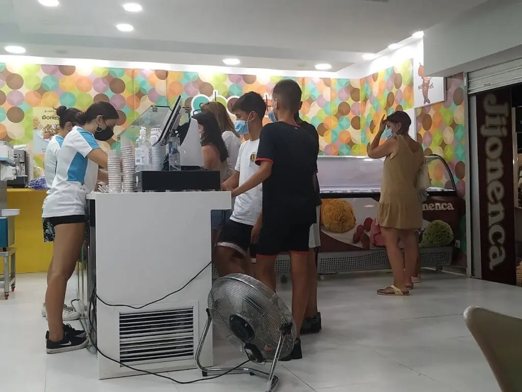 Intérieur de Jijonenca avec des clients qui commandent une glace au comptoir