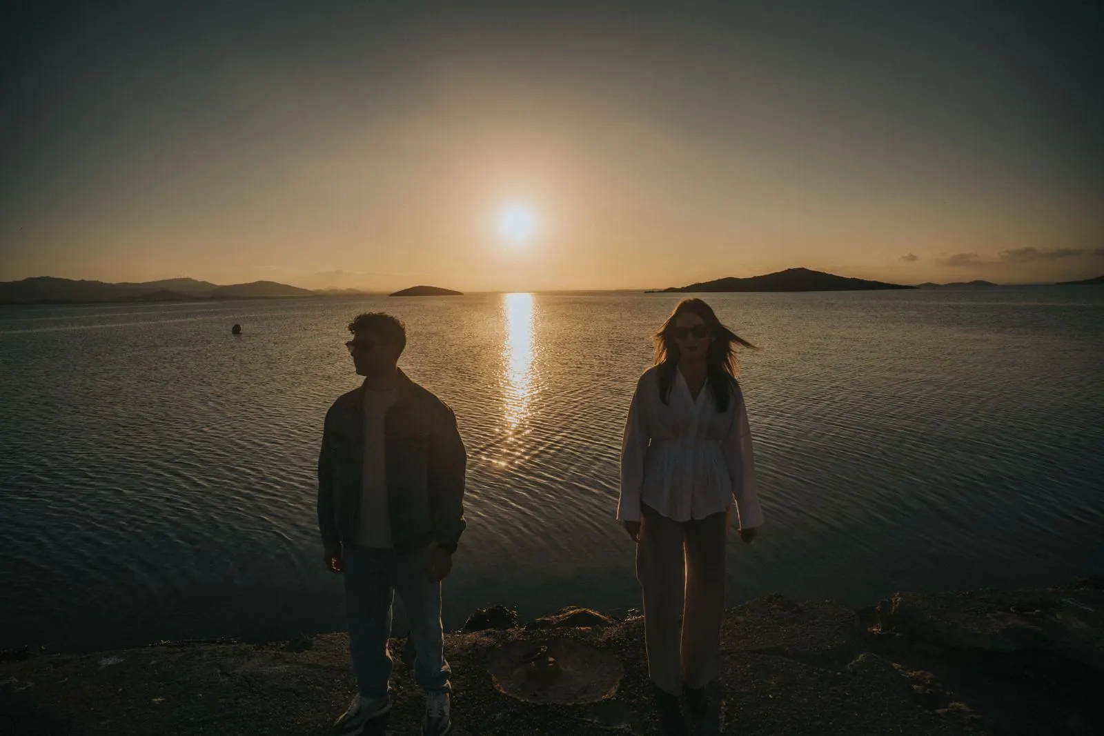 Backlit silhouette of a couple beside Mar Menor at sunset, photograph by José Espinosa