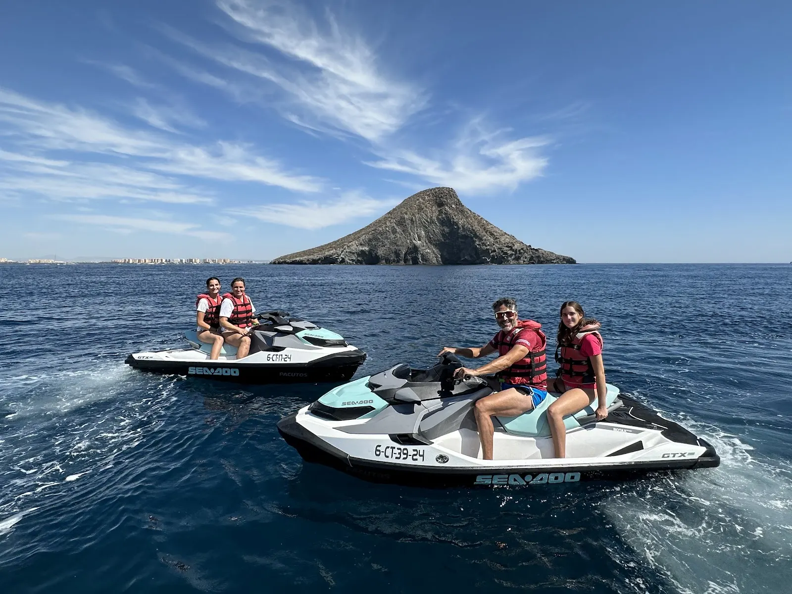Group on Mediterráneo Jet jet skis beside an islet off the coast
