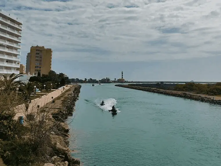 Kanal des Estacio mit Jetskis und dem Leuchtturm im Hintergrund