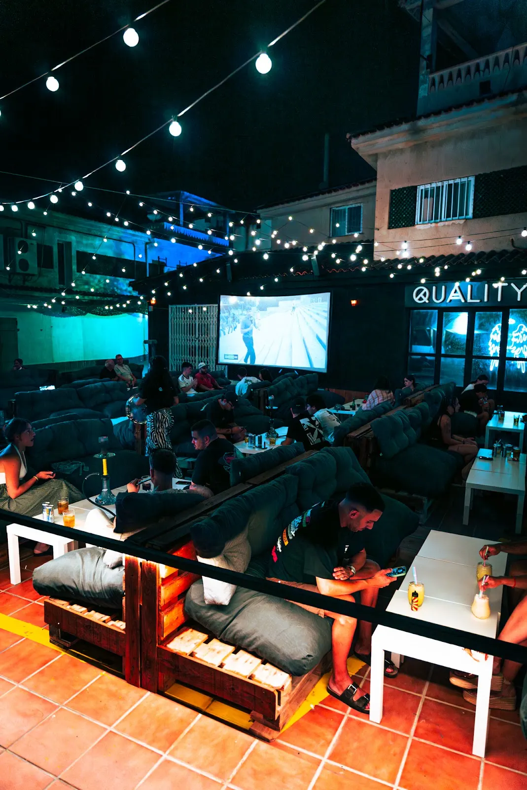 Terrasse von Quality Pub mit Großbildleinwand und abendlicher Atmosphäre