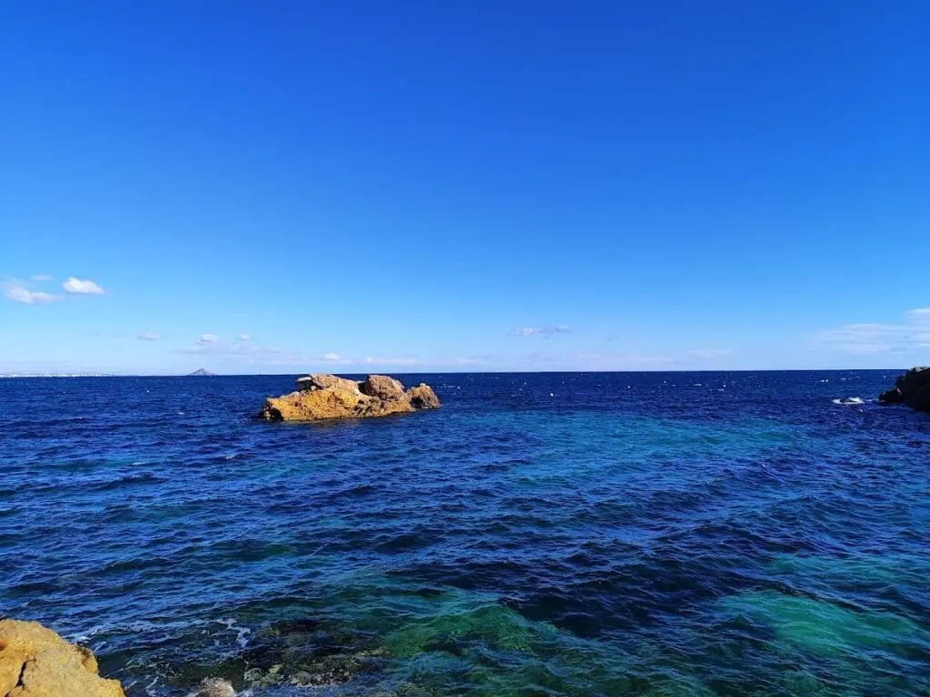 Ockerfarbener Fels in klarem Wasser an der Küste von Cabo de Palos