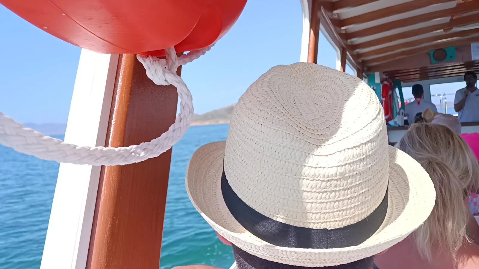 Passagier mit Strohhut an Bord des Bootes von Solaz Lines auf dem Weg zur Isla Grosa