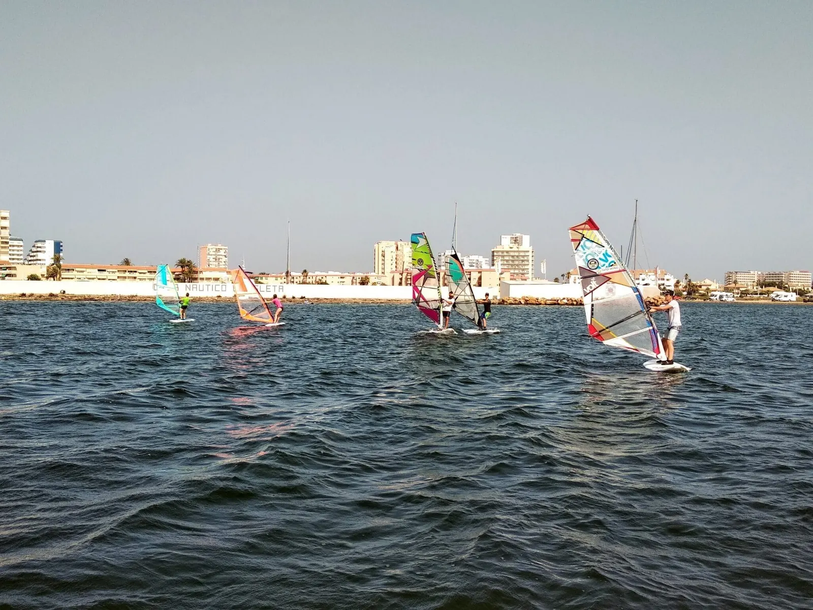 Tatowind Sailing School windsurfing students beside the Club Náutico La Isleta