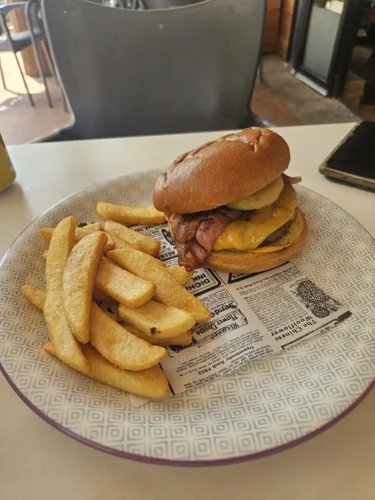 Burger mit Pommes frites, serviert auf der Terrasse von Teckel Bar