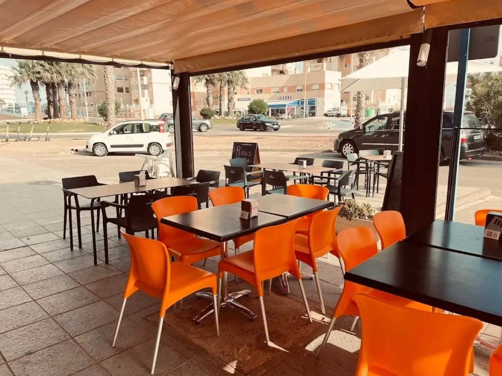 Terrasse mit orangefarbenen Tischen und Stühlen von Va & Ven