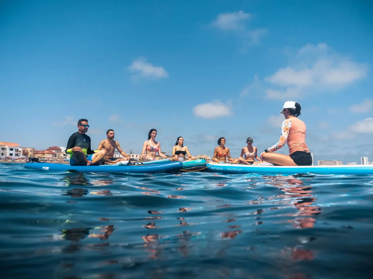 Gruppe beim SUP-Yoga auf Stand-up-Paddle-Boards im Meer von Cabo de Palos mit WIMBI