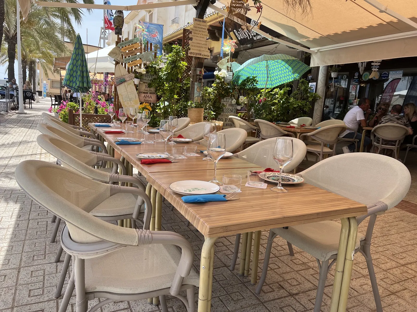 Terrasse von Yemanjá mit gedeckten Tischen an der Hafenpromenade