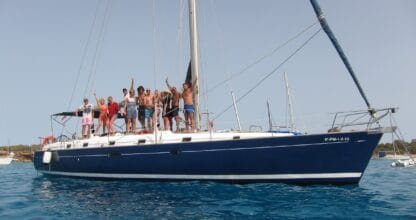 Grupo de personas celebrando a bordo de un velero azul marino fondeado en aguas turquesas con Alina Sailing