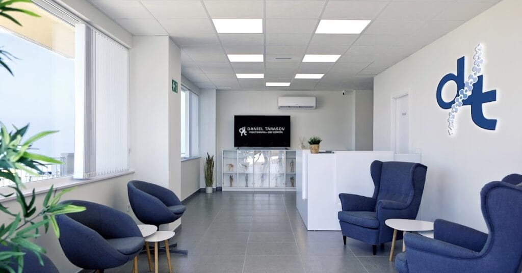 Recepción moderna con sillones azules y logo Daniel Tarasov en clínica de fisioterapia y osteopatía en La Manga del Mar Menor