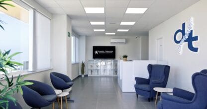 Recepción moderna con sillones azules y logo Daniel Tarasov en clínica de fisioterapia y osteopatía en La Manga del Mar Menor