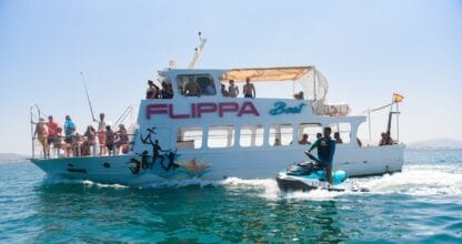 Barco Flippaboat lleno de pasajeros navegando en el Mar Menor junto a una moto de agua en un día soleado