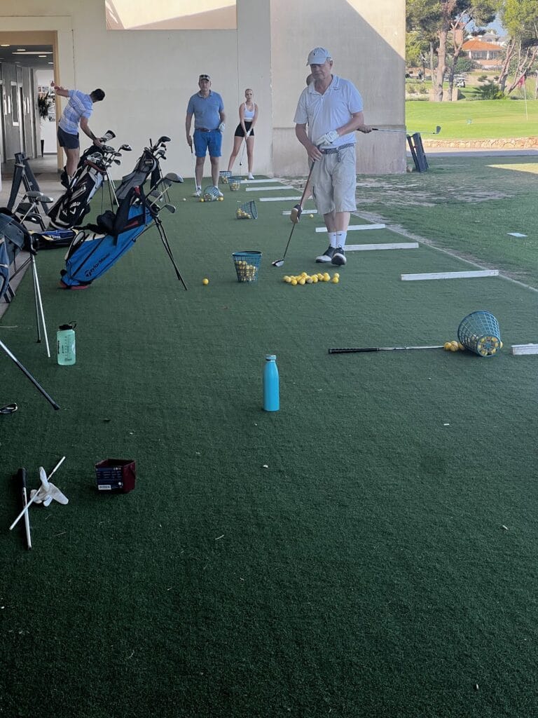 Golfistas practicando en el campo de entrenamiento de la Academia de Golf de La Manga Club con pelotas amarillas