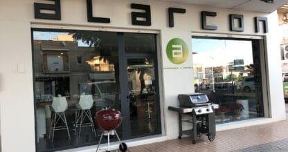 Fachada exterior de Alarcon Carpintería y Cocinas con barbacoas expuestas en la acera en La Manga del Mar Menor