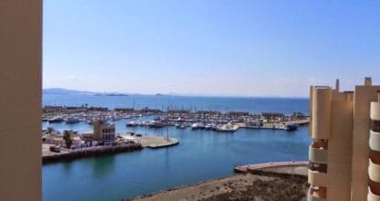 Vista de puerto deportivo con veleros atracados y el Mar Menor al fondo desde apartamento Alina365
