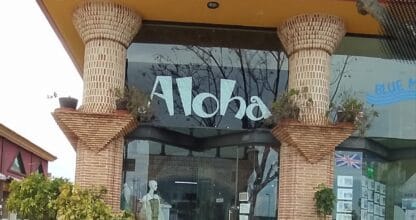 Fachada exterior de la boutique Aloha moda y complementos con columnas de ladrillo visto y escaparate con maniquí en La Manga