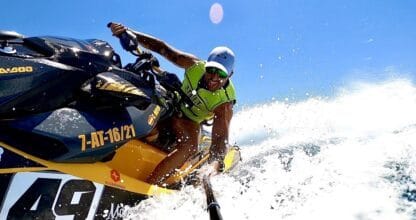 Persona con chaleco salvavidas pilotando moto de agua a alta velocidad, alquiler jet ski La Manga del Mar Menor