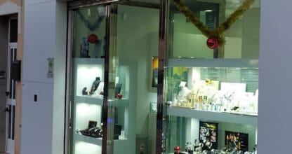 Escaparate iluminado de Antonio Cuello Joyero con vitrinas de joyas y rótulo en La Manga del Mar Menor