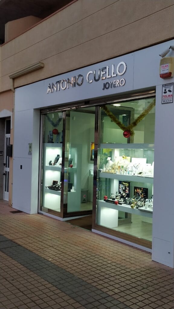 Escaparate iluminado de Antonio Cuello Joyero con vitrinas de joyas y rótulo en La Manga del Mar Menor
