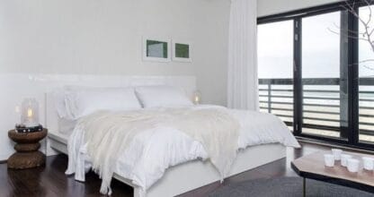 Dormitorio blanco y luminoso con cama doble y ventanal con vistas, propiedad gestionada por AP Property